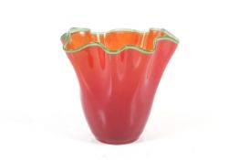 An orange glass vase. With a green 'piped' rim in the style of Vasart.