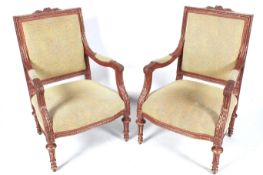 A pair of contemporary rouge and gilt wood open arm chairs.