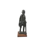A traditional African carving of an old man with a walking stick.