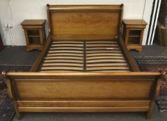 A modern cherry wood finish double bed frame and pair of matching bedside cabinets.