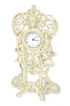 A painted cast spelter cased mantel clock. With cherubs, a mask, floral and scroll decoration.