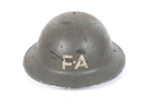 A WWII Civil Defence Helmet. Dated 1941, marked FA meaning first aid.