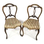 A pair of early Victorian walnut overstuffed balloon back chairs.