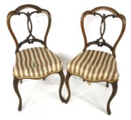 A pair of early Victorian walnut overstuffed balloon back chairs.