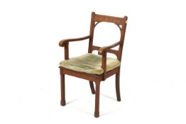 An Arts & Crafts Cotswold style oak elbow chair.