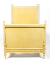 A carved yellow painted wooden single bed frame. With leaf and pineapple decoration.