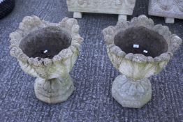 A pair of composite stone garden urns.