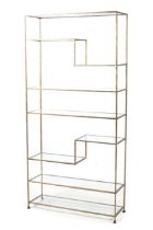 A continental gilt metal freestanding shelf. Hammered metal finish and glass shelves.