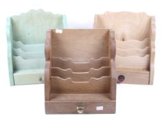 Three handmade wooden letter stationery racks. One stained in green and with a single drawer, Max.