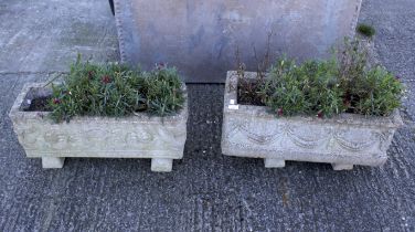 A pair of trough composite stone planters.