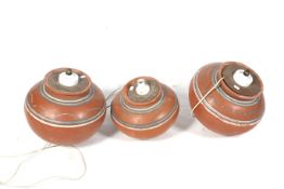 Three terracotta lamp bases. Of graduating sizes, all of rounded form, with painted decoration, Max.