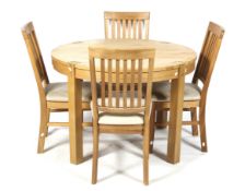 A circular retro style extending table and set of four chairs. Blonde oak, exposed joints. D110cm.