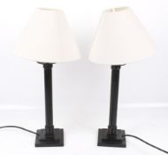 A pair of black painted metal table lamps. On a square two step base.