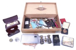 An assortment of collectables contained within a cigar box.