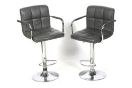A pair of contemporary adjustable bar stools.