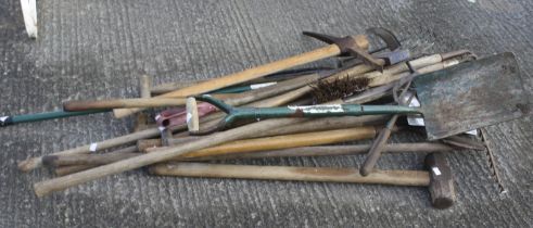 A collection of assorted garden hand tools. Including a lawn rack, shovels, etc.