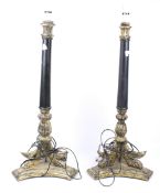 A pair of gilt and black lacquer table lamps. On a trefoil base with claw feet above.
