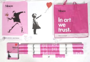 Seven Banksy Moco Museum posters and a book.