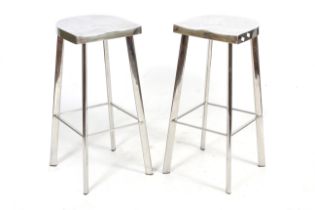 A pair of chrome metal bar stools.
