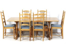 A pine kitchen table and set of six Ercol (blue label) ladderback chairs.