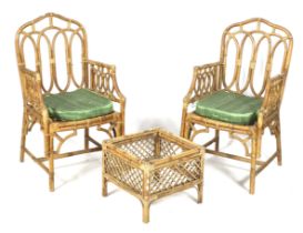 A pair of wicker and bamboo open armchairs and a side table.