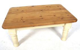 A contemporary pine top coffee table. With painted supports.