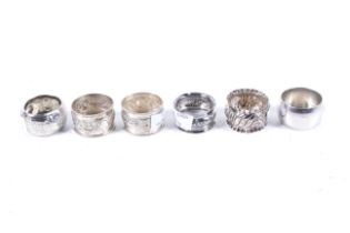 Three various English silver napkin rings, two Indian examples and a plated example.