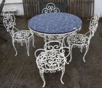 A circular wirework garden table and a set of four matching chairs.
