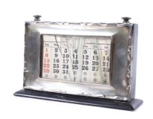 A silver mounted ebonised wood perpetual desk calendar.