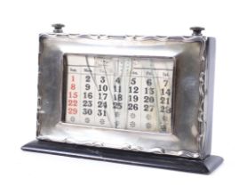 A silver mounted ebonised wood perpetual desk calendar.