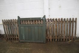 Two sections of wooden picket fencing and a gate.