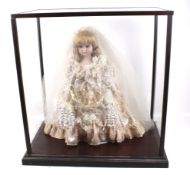 A glass display cabinet containing a doll.