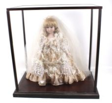 A glass display cabinet containing a doll.