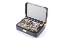 A grey leather and snake skin design jewellery box enclosing a collection of vintage jewellery.