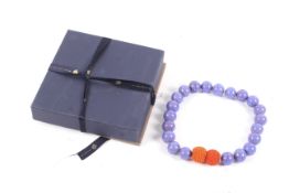 Kettenmacherin, a blue glass bead necklace on an orange twin-bead magnet clasp.