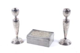 A pair of white metal candlesticks in Persian style and a box.