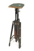 A vintage wooden tripod. Painted black with a leather carry handle.