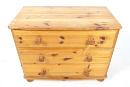 A contemporary pine chest of three drawers. On bun feet.