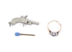 A 9ct white and yellow gold and small sapphire and diamond three stone ring and a miniature pistol.