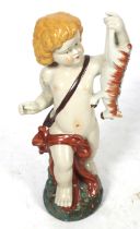 A polychrome ceramic figure. Modlled as cherub holding a cow.