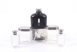 A plated hip flask, a silver mounted dressing table jar and various dressing table bottles.