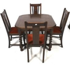 A 1940s oak draw leaf dining table and a set of four chairs.