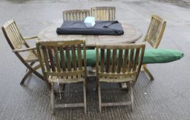 A garden teak table, set of six foldable chairs and an umbrella.