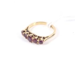 A vintage gold and oval violet-ish paste five stone ring.
