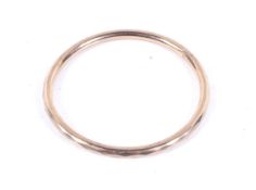 An early 20th century 9ct rose gold faceted hollow round section 'slave' bangle.