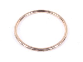 An early 20th century 9ct rose gold faceted hollow round section 'slave' bangle.