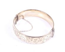 A '1/5th 9ct gold metal core' part foliate engraved hinged broad bangle. 30.