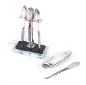 An Art Deco silver mounted and lucite based manicure stand for four pieces.