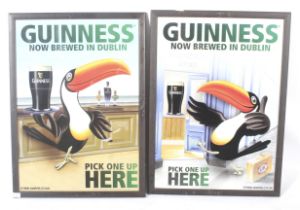 A pair of reproduction Guinness advertising posters.