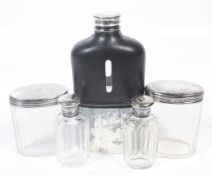 A plated hip flask, a silver mounted dressing table jar and various dressing table bottles.